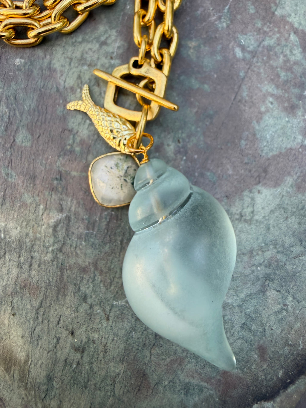 pale blue, acrylic shell with gold fish and agate charm on gold link chain, front toggle closure