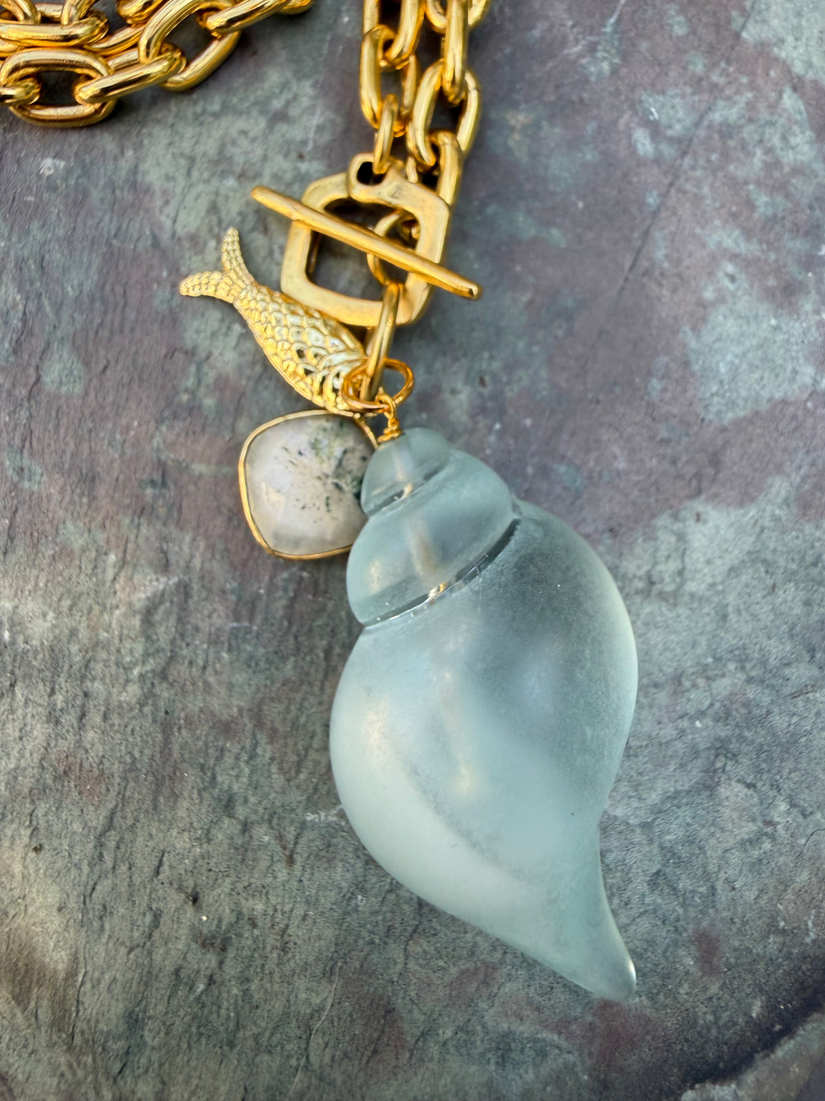 pale blue, acrylic shell with gold fish and agate charm on gold link chain, front toggle closure